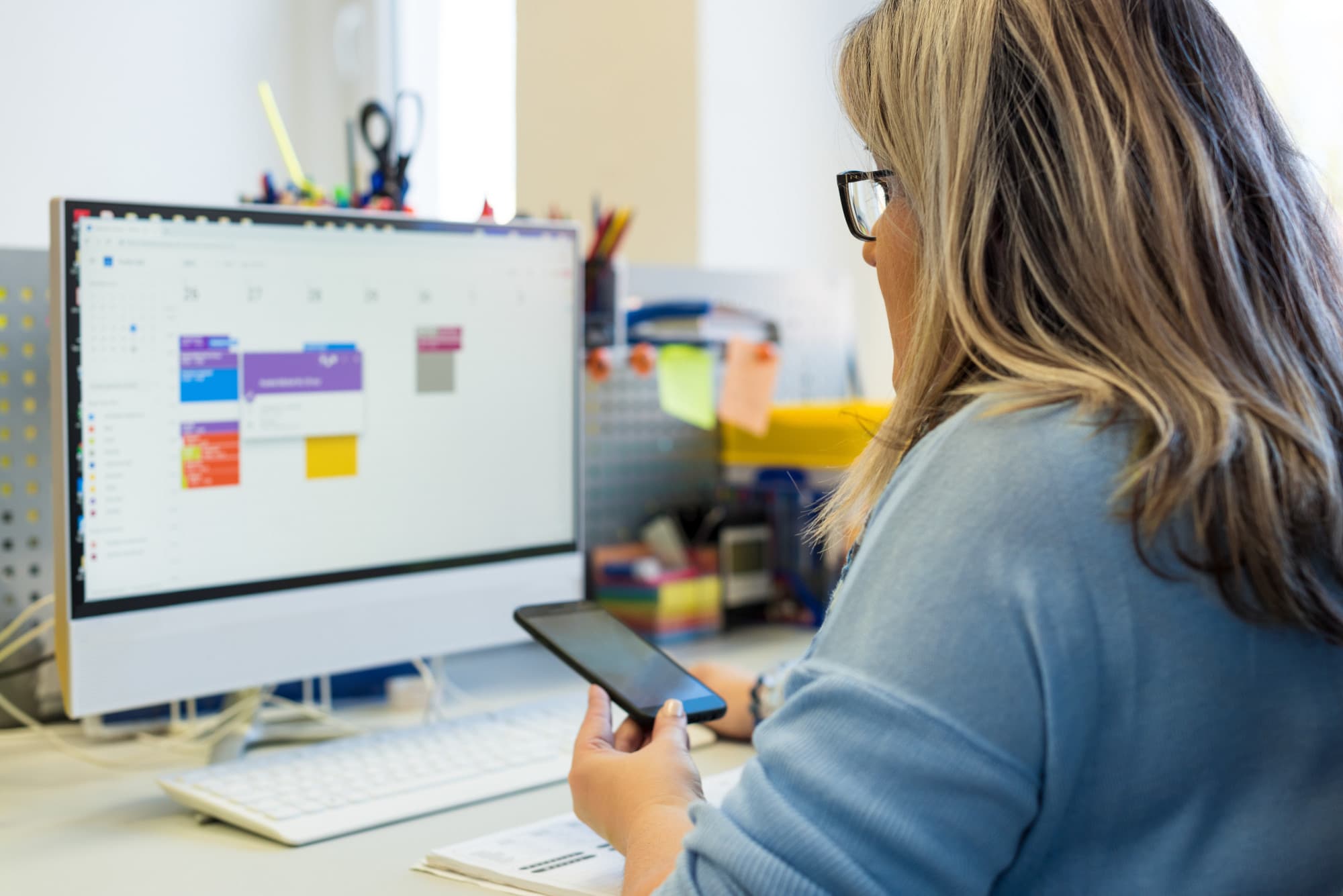 Female child therapist in an office during a phone call, using online calendar to schedule patients appointments. Calendar Planner Organization Management Concept.